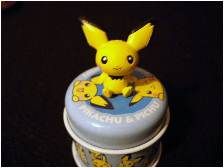 A close-up of my Pichu tin. It's very small, so it doesn't hold much, but it's so cute! :D There's the Pichu figure on top, plus the Pichu design on t