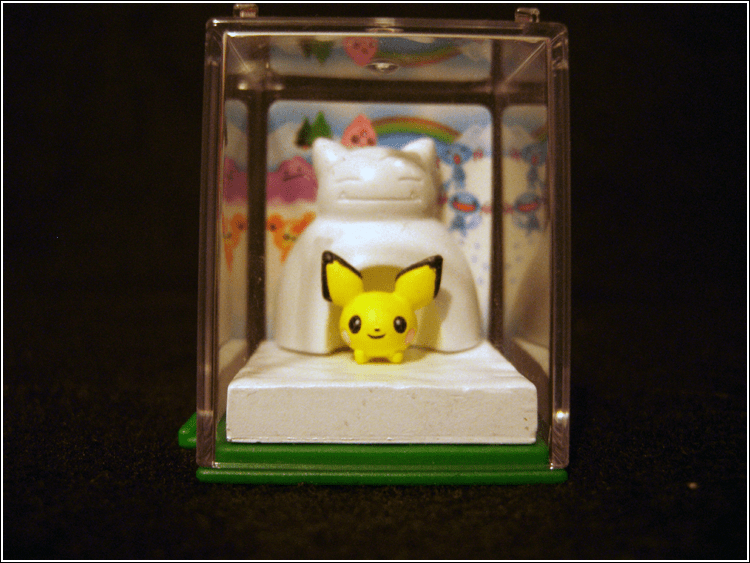 A close-up of the affectionately named "Winterchu".

A little Pichu crouching under a Snorlax snow fort. A little background card goes under the plast